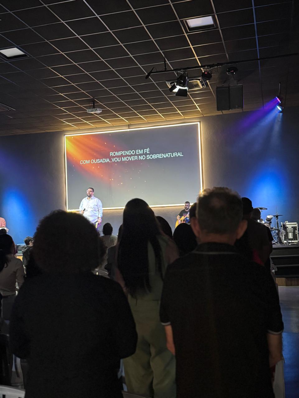 Culto com iluminação cênica colorida no palco